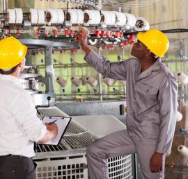 textile factory manager and worker checking yarn on weaving machine